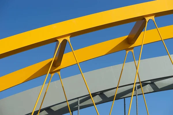 Ujęcie z bliska żółtego metalowego łuku pod błękitnym niebem — Zdjęcie stockowe