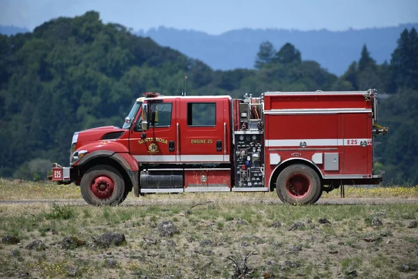 Lado de un camión de bomberos estacionado en medio de una carretera en el campo. — Foto de Stock