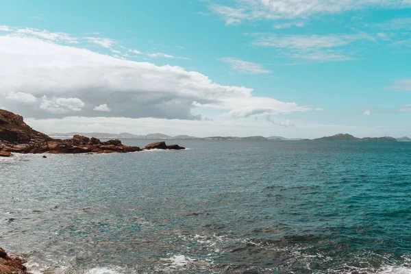 曇り空の下、緑に覆われた島に囲まれた海の風景 — ストック写真