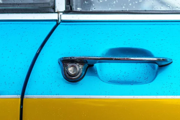 Closeup shot of the door handle of a blue and yellow car — Stock Photo, Image