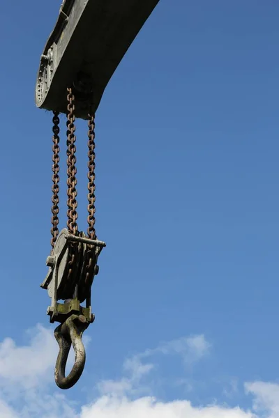 Closeup shot of a crane hook with the clear sky in the background — Stock Photo, Image