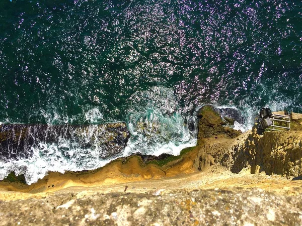 Alto ângulo disparado a partir do topo do penhasco com ondas do mar batendo na rocha — Fotografia de Stock