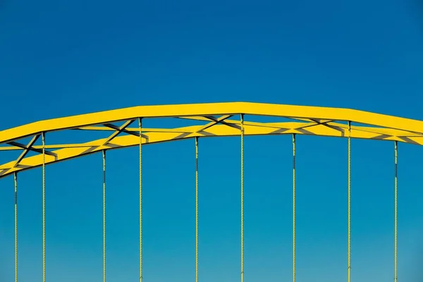 Zbliżenie ujęcia przedniej części żółtego łuku pod błękitnym niebem — Zdjęcie stockowe