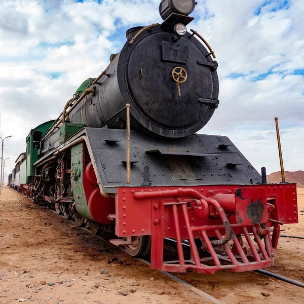 在多云的天空下，红色和黑色的火车在沙漠上的特写镜头 — 图库照片