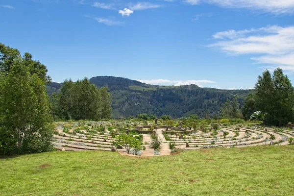 Prachtige betonnen doolhof omgeven door gras bedekte velden en bomen — Stockfoto