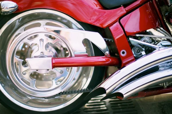 햇볕 아래 길을 달리고 있는 빨간 오토바이의 바퀴를 감고 있는 모습 — 스톡 사진