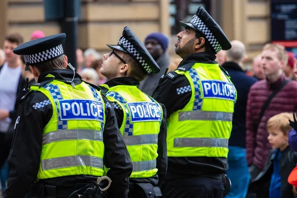 3 policiers en gilets jaunes regardant le grand écran — Photo