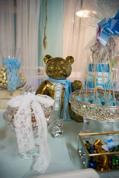 Foto vertical de una estatua de oso dorado sobre la mesa de fiesta con decoraciones. — Foto de Stock