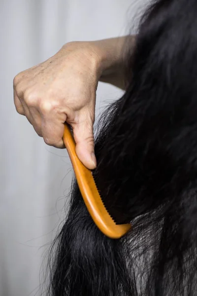 Függőleges felvétel egy nőről, aki hosszú haját fésüli. — Stock Fotó