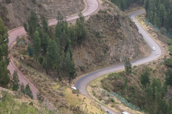 Vuelo aéreo de una carretera asfaltada que atraviesa las montañas cubiertas de árboles. — Foto de Stock