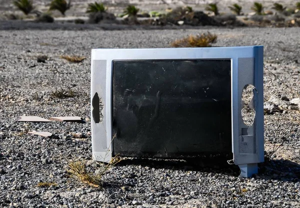 Messa a fuoco selettiva di uno schermo rotto di una televisione posta su una superficie rocciosa — Foto Stock