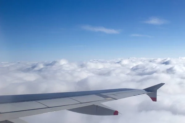 Vuelo sobre una nube cerrada con el ala del avión en la imagen — Foto de Stock