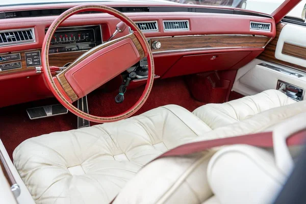 Foto gran angular del interior de un coche, incluyendo la rueda de dirección roja y asientos blancos. — Foto de Stock