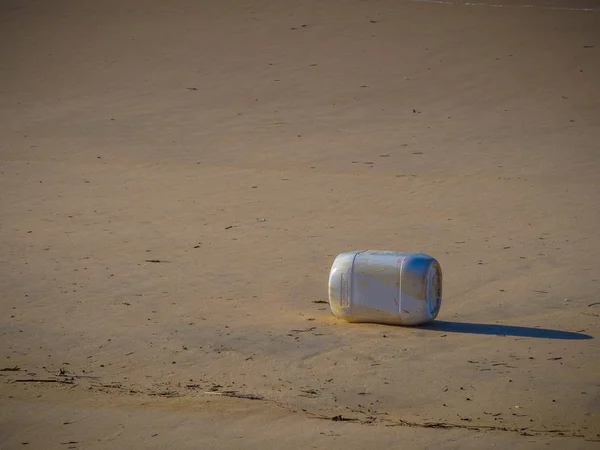 Antiguo recipiente de plástico dejado en la playa durante el día - concepto de contaminación ambiental. — Foto de Stock