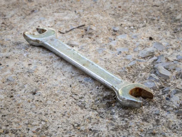 Oude roestige sleutel op een betonnen ondergrond overdag — Stockfoto