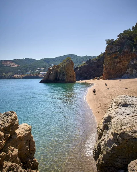 Függőleges lövés a sziklák a tenger partján a Playa Illa Roja nyilvános strand Spanyolországban — Stock Fotó