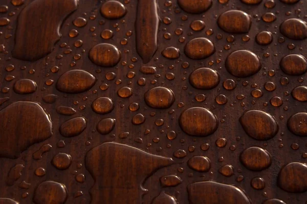 Strzał zbliżeniowy kropel wody na drewnianej powierzchni — Zdjęcie stockowe