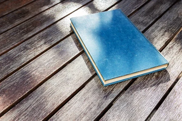 Nagy szög lövés egy kék könyv egy fa felületen — Stock Fotó