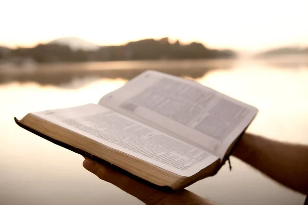 Närbild av en bok med kullar och en sjö på suddig bakgrund under solljuset — Stockfoto