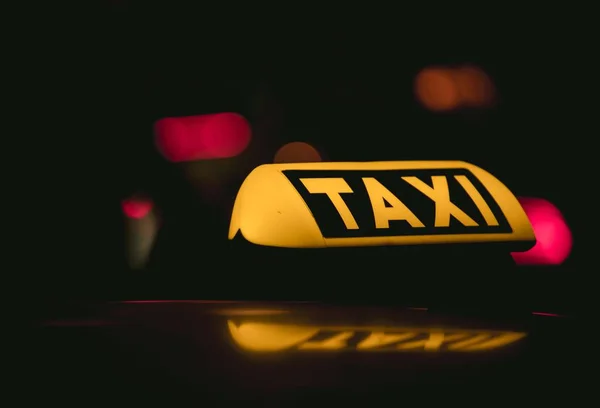 어두운 배경에 배치 된 택시 사인의 클로즈업 사진 — 스톡 사진