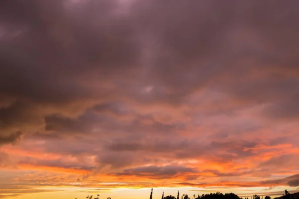 Céu apedrejador durante o pôr do sol com cores rosa e amarelo alaranjadas — Fotografia de Stock