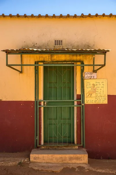 Крупный план зелёной двери на красно-жёлтом здании — стоковое фото