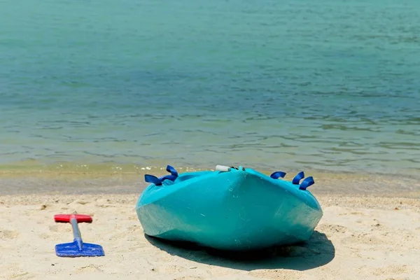 Голубая весельная лодка на пляже с красивым океаном на заднем плане — стоковое фото