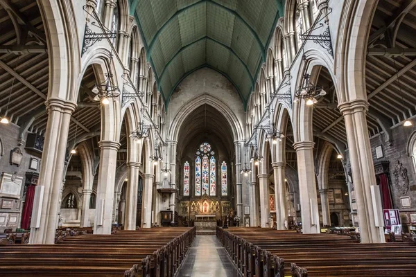 Vue intérieure d'une église avec des icônes religieuses sur les fenêtres et les arches en pierre — Photo