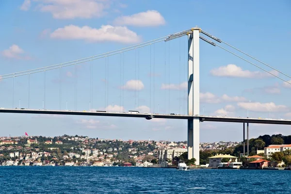 Bassa angolazione di un ponte sul mare con una città sulle sue rive — Foto Stock