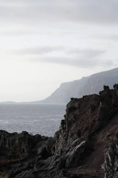 Vertikal hög vinkel skott av stenar på stranden av havet på en dyster dag — Stockfoto