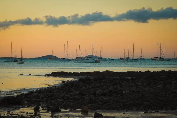 Meer mit Schiffen darauf, umgeben von Strand und Hügeln während des Sonnenuntergangs am Abend — Stockfoto