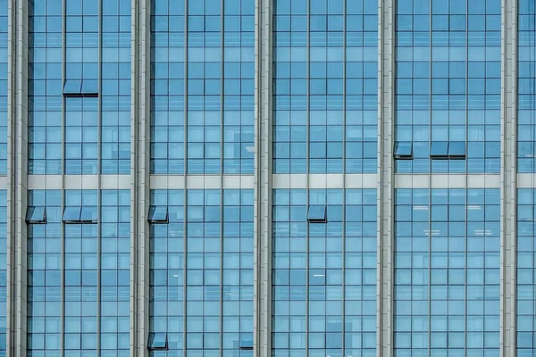 Foto de cierre de las ventanas azules de un rascacielos grande. — Foto de Stock