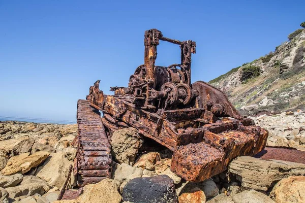 Restos de un viejo tanque oxidado en una costa rocosa — Foto de Stock