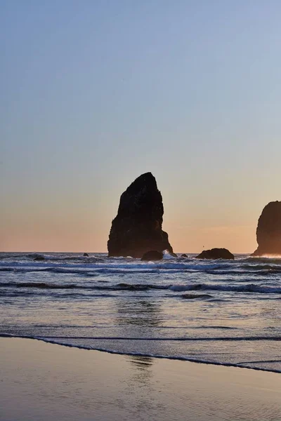 Vertical shot of the famous Haystack Rock on the rocky shoreline of the Pacific Ocean — Stock Photo, Image