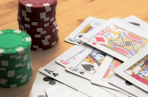 Hög vinkel skott av en spelkort och marker poker på en träyta — Stockfoto