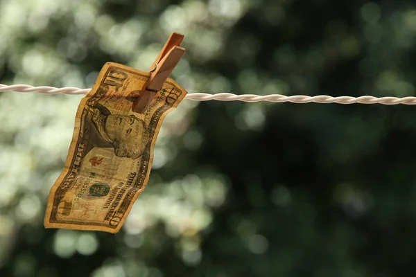 Selektywne ujęcie banknotu dolarowego powieszonego na drucie szpilką do ubrań — Zdjęcie stockowe