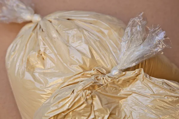 Duży kąt ujęcia plastikowych toreb pełnych mąki na różowej powierzchni — Zdjęcie stockowe