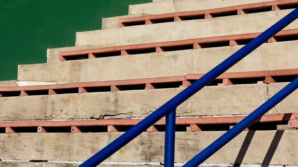 Escadas de concreto com assentos de madeira por um corrimão azul — Fotografia de Stock