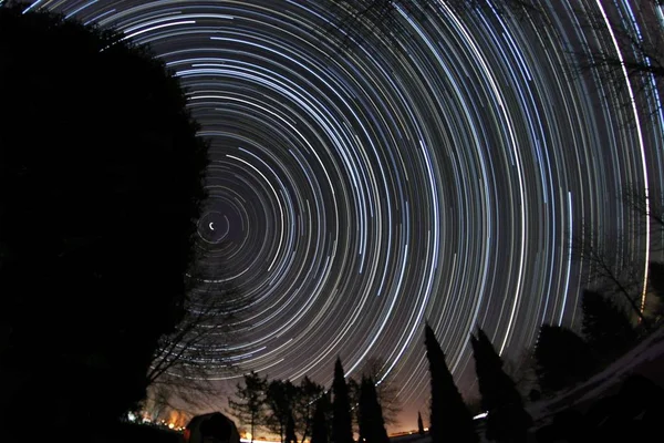 Vacker stjärnspår fotografi med en silhuett av träd — Stockfoto