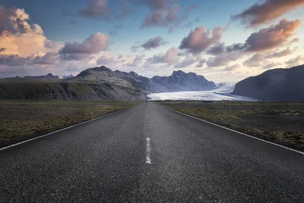 Smalle weg die leidt naar hoge rotsachtige bergen in Skaftafell National Park in IJsland — Stockfoto