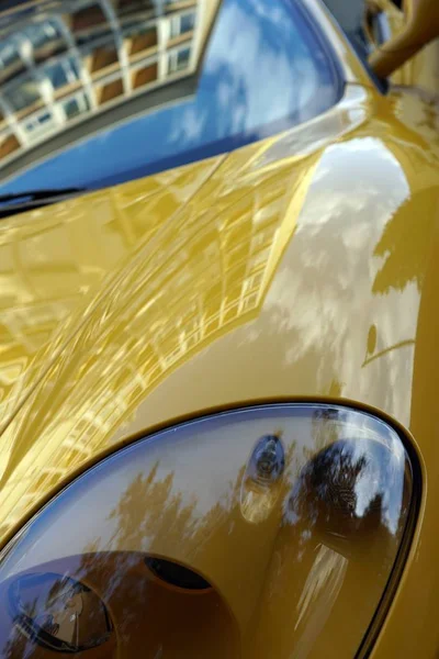 Primo piano verticale dei fari di una vettura sportiva gialla — Foto Stock