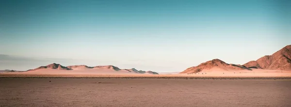 Tiro panorâmico de tirar o fôlego de planícies do deserto na Namíbia África com colinas no fundo — Fotografia de Stock