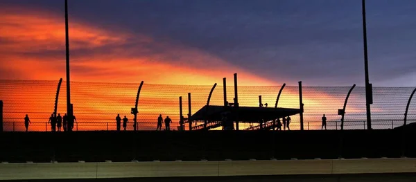 Eine Silhouettenaufnahme Geschäftiger Menschen Mit Einer Landschaft Des Sonnenuntergangs — Stockfoto