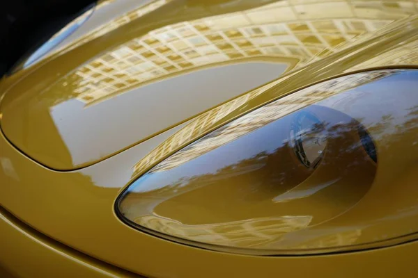 Closeup shot of the headlights of a yellow sports car — Stock Photo, Image