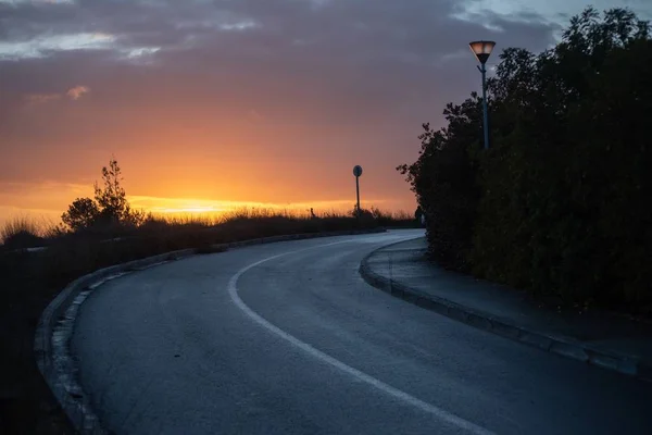 Una Carretera Sinuosa Cielo Nublado Atardecer Fondo — Foto de Stock