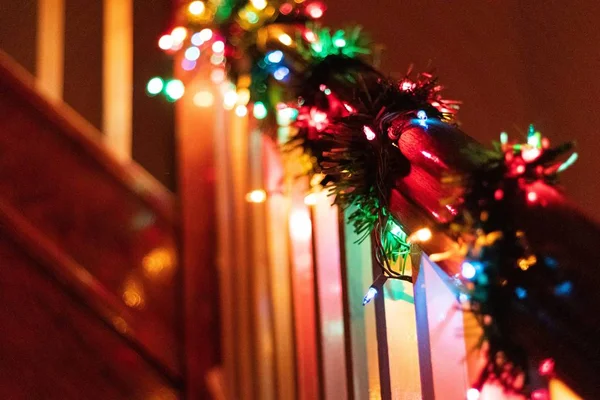 Tahta korkuluklara dolanmış Noel ışıklarının seçmeli odak noktası. — Stok fotoğraf