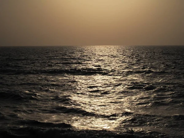 Schöne Aufnahme des Meeres, das die Sonnenlichter vor nebligem Hintergrund reflektiert — Stockfoto