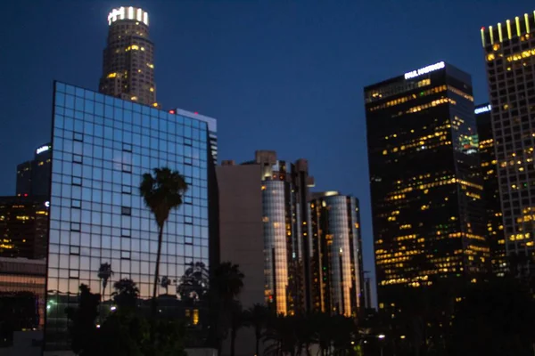 Low angle shot of modern business buildings in the middle of the city during nighttime — Stock Photo, Image