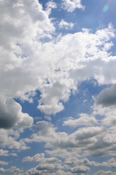 Вертикальный снимок красивых пушистых облаков в голубом небе — стоковое фото