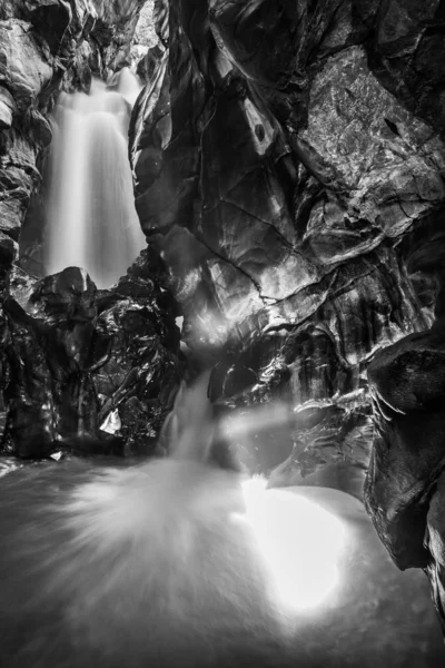 Eine Vertikale Graustufenaufnahme Eines Wasserfalls Inmitten Von Klippen — Stockfoto